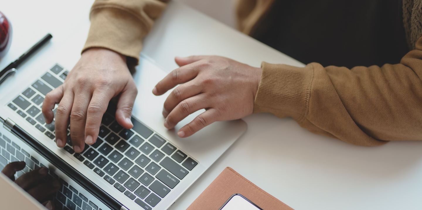 Person in Brown Long Sleeve Shirt Using Macbook Pro